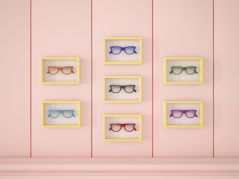 Bunte Gläser in gelben Rahmen hängen an einer rosa Wand, lizenzfreies Stockfoto