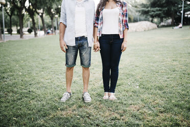 Young couple in love standing on a meadow in a park holding hands - JRFF000113