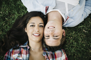 Portrait of young couple in love lying head to head on a meadow - JRFF000115