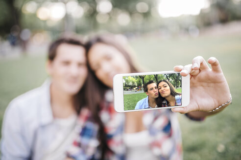 Foto auf dem Display eines Smartphones von einem verliebten jungen Paar - JRFF000118