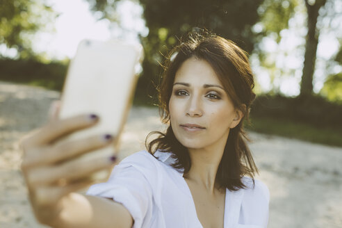 Porträt einer Frau, die ein Selfie mit ihrem Smartphone macht - MFF002246