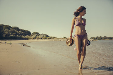 Germany, Cologne, woman walking on the beach along waterside of Rhine River - MFF002270