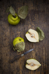 Whole and sliced quinces and a pocket knife on wood - LVF003980