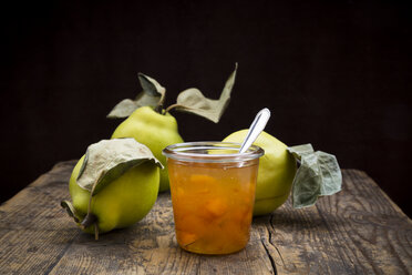 Quinces and a glass of quince jam on wood - LVF003986