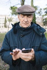 Porträt eines älteren Mannes mit Smartphone in einem Park - GIOF000273