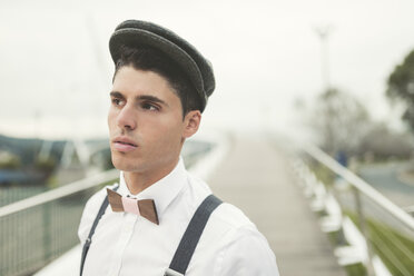 Portrait of young man wearing beret and a wooden bow tie - RAEF000537