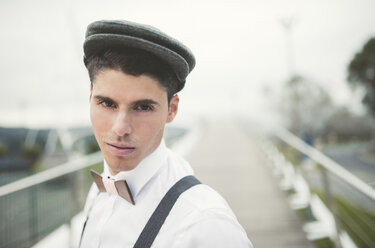 Portrait of young man wearing beret and a wooden bow tie - RAEF000538