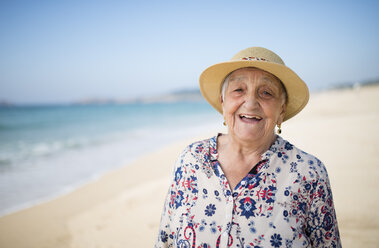 Spain, Ferrol, portrait of happy senior woman standing on the beach - RAEF000541