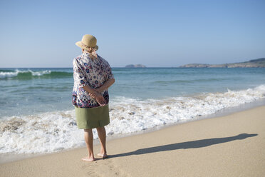 Spanien, Ferrol, Rückenansicht einer am Strand stehenden älteren Frau - RAEF000542