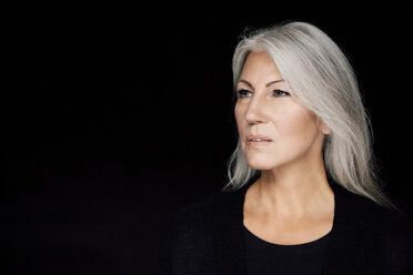 Portrait of mature woman with grey hair in front of black background - CHAF001517