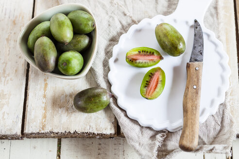 Geschnittene und ganze Mini-Kiwi auf dem Teller - SBDF002297