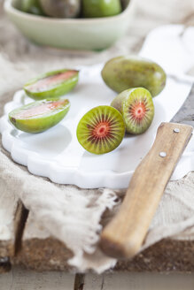 Geschnittene und ganze Mini-Kiwis auf dem Teller - SBDF002298