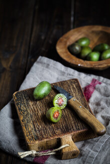 Geschnittene und ganze Mini-Kiwi auf einem Schneidebrett aus Holz - SBDF002299