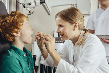 Eine Ärztin untersucht einen kleinen Jungen mit einem Spatel - MFF002314