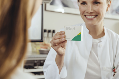 Arzt zeigt Patientin Medikamente, lizenzfreies Stockfoto