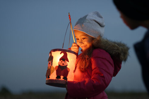 Smiling little girl with self-made paper lantern in the evening - LBF001245