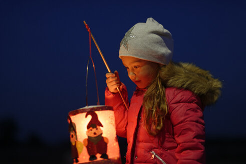 Portrait of little girl with lighted paper lantern on St. Martin's Day at twilight - LBF001249