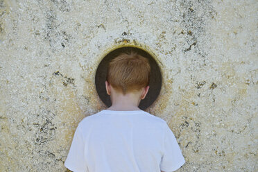 Junge späht durch ein Loch in der Wand - JEDF000254