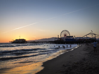 USA, Los Angeles, Blick auf den Santa-Monica-Pier und den Pacific Park bei Sonnenuntergang - SBDF002307