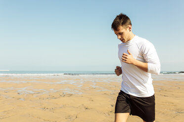 Spain, Asturias, Gijon, young man running on the beach - MGOF000841