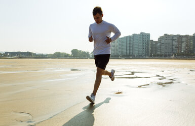 Spanien, Asturien, Gijon, junger Mann läuft am Strand - MGOF000843