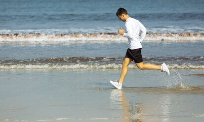 Spanien, Asturien, Gijon, junger Mann läuft am Strand - MGOF000844