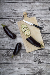 Aubergines on chopping board, knife - LVF003994