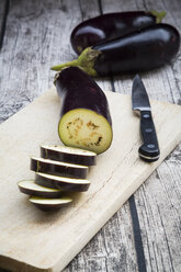 Aubergines on chopping board, knife - LVF003995