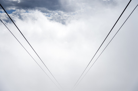 Deutschland, Bayern, Oberstdorf, Seile der Nebelhorn-Seilbahn verschwinden im Nebel, lizenzfreies Stockfoto