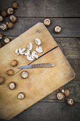 Crimini mushrooms on chopping board, knife - LVF004010