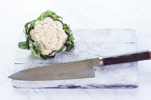 Weißer Blumenkohl auf Schneidebrett, Messer, lizenzfreies Stockfoto