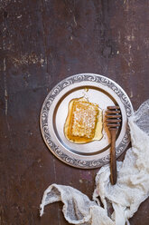 honeycomb with honey and honey spoon on tin plate - SBDF002345