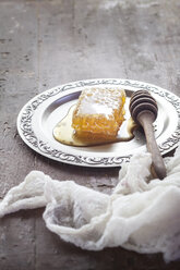 honeycomb with honey and honey spoon on tin plate - SBDF002347