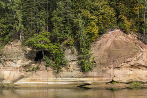 Lettland, Gauja-Nationalpark, Teufelshöhle, Wald und Sandsteinfelsen am Gauja-Fluss, lizenzfreies Stockfoto