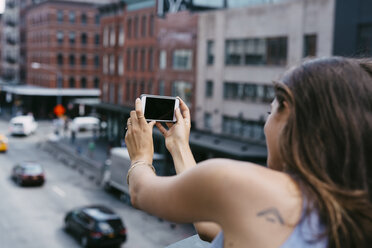USA, New York City, young woman taking a selfie with cell phone - GIOF000286