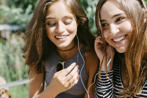Zwei glückliche Freunde teilen sich Kopfhörer - GIOF000298