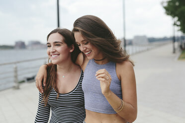 USA, New York City, two happy friends walking along Hudson River - GIOF000325