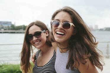 USA, New York City, two happy friends wearing sunglasses at Hudson River - GIOF000327
