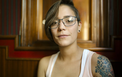 Portrait of tattooed young woman wearing glasses - MGOF000853
