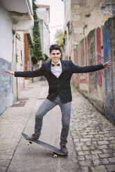 Elegant young man on skatebaord keeping the balance - RAEF000545