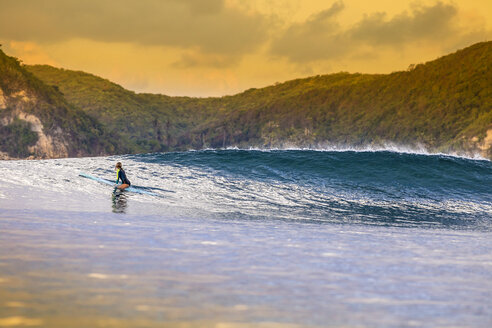 Indonesien, Lombok, Surferin auf Surfbrett sitzend - KNTF000110