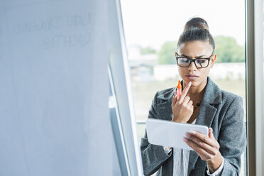 Junge Frau im Büro mit digitaler Tafel am Flipchart - UUF005805