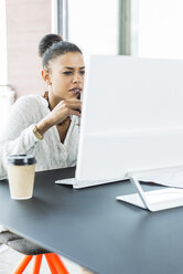 Junge Frau im Büro bei der Arbeit am Computer - UUF005818