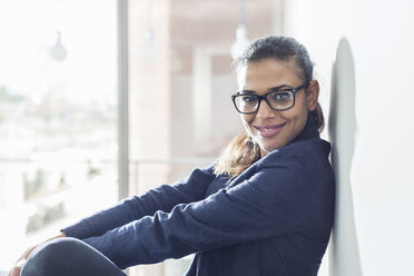 Portrait of confident young woman leaning against a wall - UUF005843