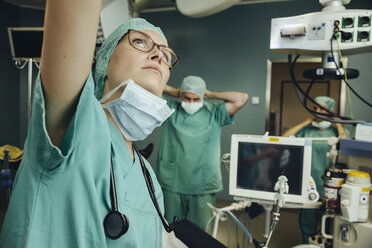 Chirurgin greift im Operationssaal nach oben - MFF002322