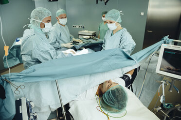 Team operating a woman on surgery table - MFF002327