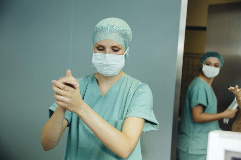 Chirurgin desinfiziert ihre Hände vor der Operation - MFF002342
