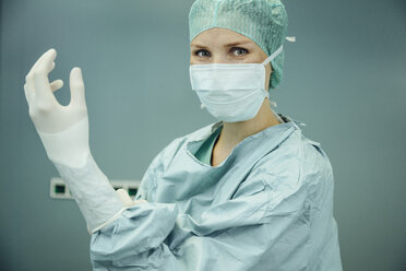 Chirurgin zieht chirurgische Handschuhe an - MFF002346