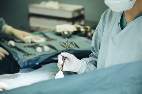Chirurg hält Klemme im Operationssaal während der Operation - MFF002353