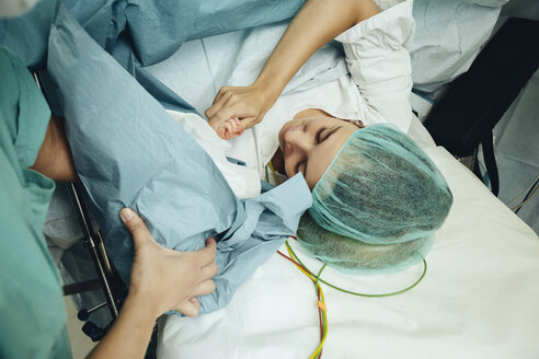 Mother touching her newborn right after c-section - MFF002360